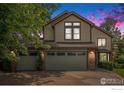 Charming two-story home with a three-car garage, well-maintained lawn, and mature landscaping at twilight at 1477 Akers Ct, Erie, CO 80516