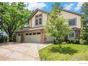 Charming two-story home with a three-car garage, well-maintained lawn, and mature trees at 1477 Akers Ct, Erie, CO 80516