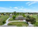 Beautiful aerial view of property featuring two garages, white fencing, and mature trees at 15545 Lipan St, Broomfield, CO 80023