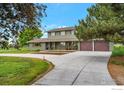 Charming two-story home featuring green paint, mature trees, and a long driveway at 15545 Lipan St, Broomfield, CO 80023