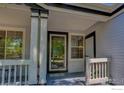 Covered porch leading to a front door with glass inset and sidelight, plus white trim and a welcome mat at 1673 Bain Dr, Erie, CO 80516