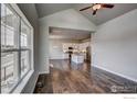 Open concept floor plan with hardwood floors seamlessly connects the living room to the kitchen at 210 High Point Dr, Longmont, CO 80504