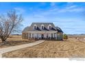 Inviting home featuring a classic design with a large front porch, perfect for enjoying the outdoors at 235 S County Road 23, Berthoud, CO 80513