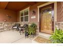 Covered front porch features a cozy seating area, charming decor, and a welcoming entrance at 336 Olympia Ave, Longmont, CO 80504