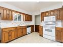 Functional kitchen featuring wooden cabinets and white appliances at 40 Cornell Dr, Longmont, CO 80503