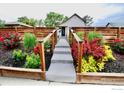 Inviting exterior with a walkway leading to the home and beautiful landscaping at 4965 Clayton St, Denver, CO 80216