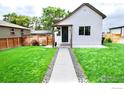 Well-manicured lawn and charming home exterior with inviting walkway at 4965 Clayton St, Denver, CO 80216