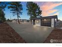 Detached two-car garage with a black door, long driveway, and nice landscaping at 6766 Zenobia Loop, Westminster, CO 80030