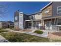 Modern townhome with gray siding, stone accents, and a private balcony at 751 Grandview Mdws Dr, Longmont, CO 80503