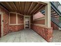 Covered entrance featuring brick accents and a secure glass door entry at 804 Summer Hawk Dr # 105, Longmont, CO 80504