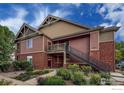 Exterior view of a condo building showing a staircase and balcony access at 804 Summer Hawk Dr # 105, Longmont, CO 80504