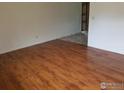 Spacious living room features hardwood floors, neutral paint and entryway into another room at 829 Hubbard Dr, Longmont, CO 80504