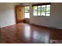 Inviting living room featuring gleaming hardwood floors, neutral walls, and a bright window at 829 Hubbard Dr, Longmont, CO 80504
