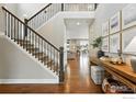 Bright entryway featuring hardwood floors, staircase, and views into other living spaces at 952 Pinecliff Dr, Erie, CO 80516