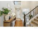 Inviting foyer with hardwood floors, staircase, and decoratively adorned console table at 952 Pinecliff Dr, Erie, CO 80516