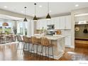 Modern kitchen with a center island, bar stools, and open to the dining area at 952 Pinecliff Dr, Erie, CO 80516