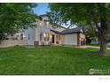Well-maintained two-story home featuring lush green lawn and mature trees in a peaceful setting at 10216 Sandy Ridge Ct, Firestone, CO 80504