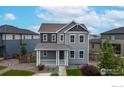 Beautiful two-story home with a cozy front porch and well-manicured lawn at 10604 Reunion Pkwy, Commerce City, CO 80022
