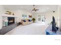 Inviting living room showcases a cozy fireplace, neutral decor, and access to outdoor patio at 10886 Pheasant Run, Littleton, CO 80125