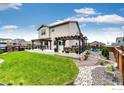 Spacious backyard with a lush lawn, a large patio, and elegant pergola for outdoor entertaining at 1191 Horsetail Loop, Elizabeth, CO 80107