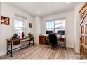 Bright home office with two work stations and lots of natural light, featuring modern decor and wood floors at 1191 Horsetail Loop, Elizabeth, CO 80107