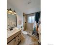 Updated bathroom featuring a modern vanity, stylish light fixture, and tiled walk-in shower at 12802 E Nevada Cir, Aurora, CO 80012
