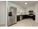 Well-lit kitchen featuring modern appliances, black and white cabinetry, and updated countertops at 12802 E Nevada Cir, Aurora, CO 80012
