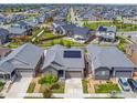 Aerial view showcases a home with solar panels in a neighborhood with manicured lawns and a sense of community at 17871 E 96Th Pl, Commerce City, CO 80022