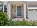 The front entryway has light stone accents and a blue door at 183 Lister Way, Erie, CO 80516