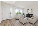 Bright living room featuring three sofas, a glass table, and new flooring at 183 Lister Way, Erie, CO 80516