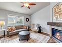 Bright living room featuring a stone fireplace, hardwood floors, and modern decor at 2132 Boise Ct, Longmont, CO 80504