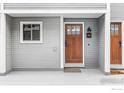 Charming condo entrance with a wooden front door, classic house numbers, and neutral siding at 2201 Pearl St # 110, Boulder, CO 80302