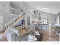 Bright open-concept living room with soaring ceilings, hardwood floors, a staircase, and contemporary decor at 2232 S Yampa Ct, Aurora, CO 80013