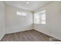 Neutral bedroom with hardwood floors and large windows offering plenty of natural light at 250 Chardon Ave, Brighton, CO 80601