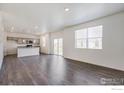 Bright living room with hardwood floors, lots of light, and opens to a contemporary kitchen at 250 Chardon Ave, Brighton, CO 80601