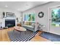 Inviting living room featuring hardwood floors, a decorative fireplace, and a large window with natural light at 309 27Th St, Boulder, CO 80305