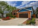Beautiful two-story home featuring mature trees, manicured lawn, and colorful flower beds creating a welcoming curb appeal at 3142 Captains Ln, Longmont, CO 80503