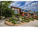 Beautiful two-story home with manicured lawn, blooming flower beds, and mature trees, creating a welcoming curb appeal at 3142 Captains Ln, Longmont, CO 80503