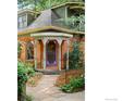 Close-up of front entry with brick facade, turret, arched windows, and purple door at 446 Pearl St, Boulder, CO 80302