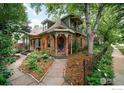 Lovely two-story home with a turret, brick facade, and landscaped front yard with stone walkway at 446 Pearl St, Boulder, CO 80302