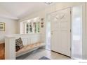 Bright foyer featuring tiled floors, paneled wainscoting, bench seating, and sidelight windows at 4483 S Meadow Dr, Boulder, CO 80301