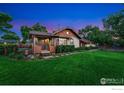 Inviting home with lush green lawn, mature trees, and a cozy covered front porch at 4900 W 6Th Ave, Denver, CO 80204