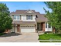 Charming two-story home with brick and siding exterior, well-manicured lawn, and a three-car garage at 4915 Sage Brush Dr, Broomfield, CO 80023
