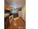 Efficient kitchen with ample cabinet space, white appliances, and hardwood floors at 4985 Twin Lakes Rd # 94, Boulder, CO 80301