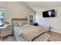 Bright bedroom with a large bed, wood floors, and a wall-mounted television at 647 Florence Ave, Firestone, CO 80520