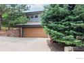 Charming home exterior with a two-car garage, beautiful trees, and a well-maintained driveway at 6503 Big Horn Trl, Littleton, CO 80125