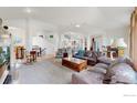 Open concept living room featuring high ceilings, view of the staircase and a glimpse of the kitchen at 6503 Big Horn Trl, Littleton, CO 80125