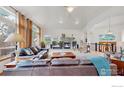 Well-lit living room with fireplace, large windows, comfortable seating area, and an open floor plan at 6503 Big Horn Trl, Littleton, CO 80125