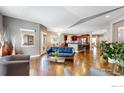 Open-concept living area boasts hardwood floors and natural light from multiple windows at 6945 N Fargo Trl, Littleton, CO 80125