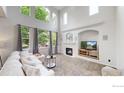 Sunlit living room boasts high ceilings, a cozy fireplace, and neutral tones at 7597 Bison Ct, Littleton, CO 80125
